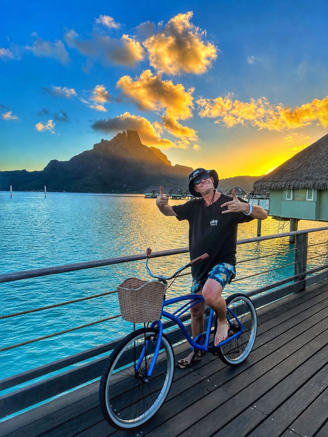 Jimmy on a bicycle beside the Bora Bora lagoon at sunset